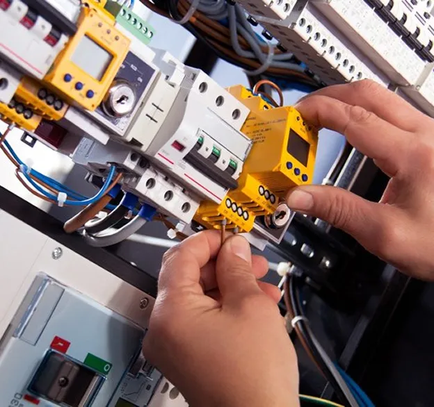 Technicien connecte un module électrique sur un tableau de distribution.